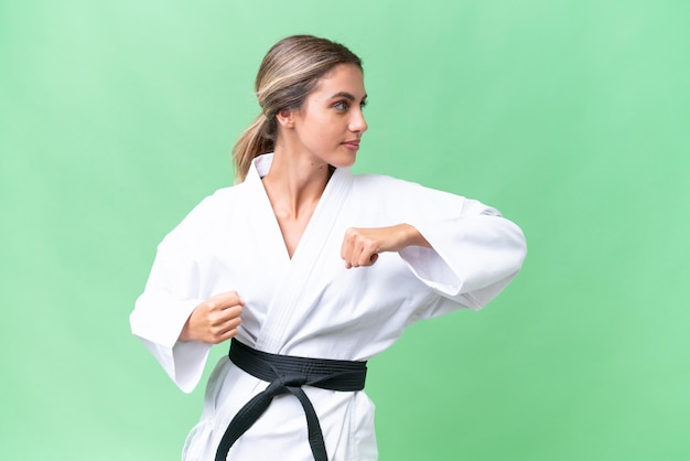 Young Uruguayan woman over isolated background doing karate