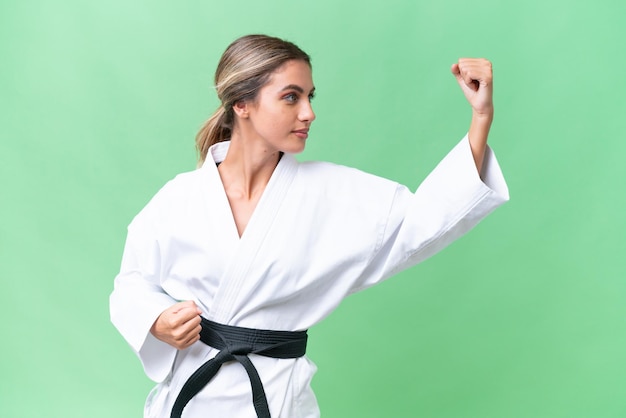 Young Uruguayan woman over isolated background doing karate