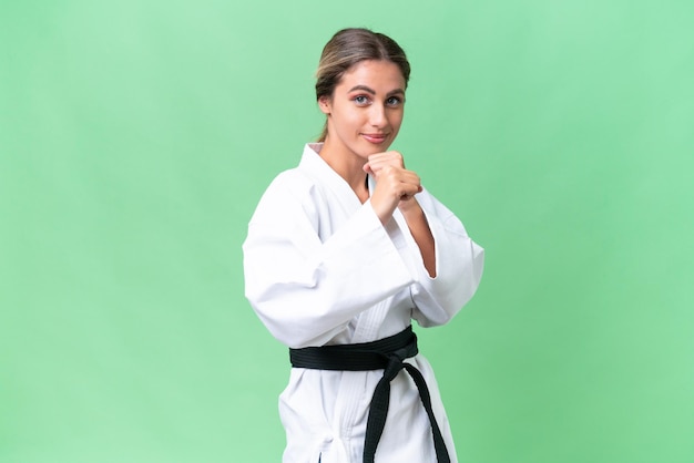 Young Uruguayan woman over isolated background doing karate