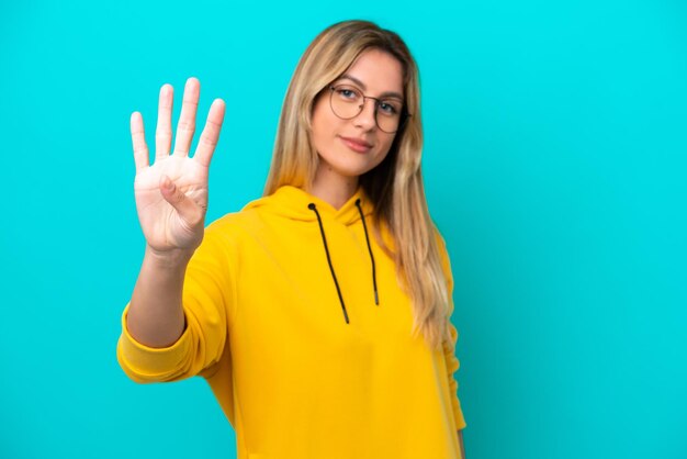 Young Uruguayan woman isolated on blue background happy and counting four with fingers