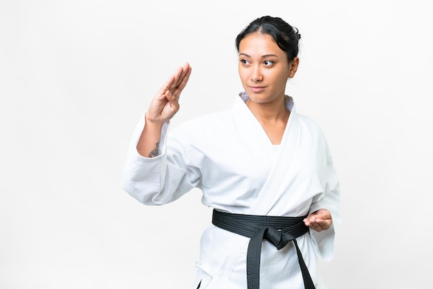 Young Uruguayan woman over isolated white background doing karate