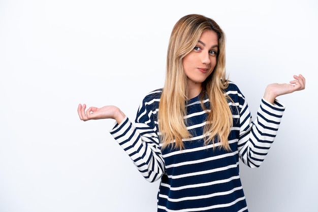 Young Uruguayan woman isolated on white background having doubts while raising hands