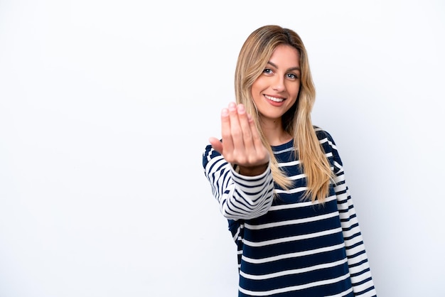 Foto giovane donna uruguaiana isolata su sfondo bianco che invita a venire con la mano felice che tu sia venuto