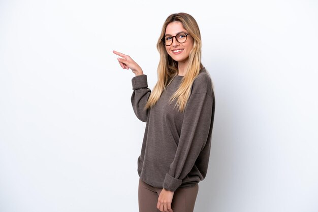 Young Uruguayan woman isolated on white background pointing finger to the side