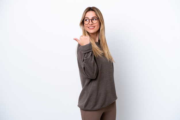 Young Uruguayan woman isolated on white background pointing to the side to present a product