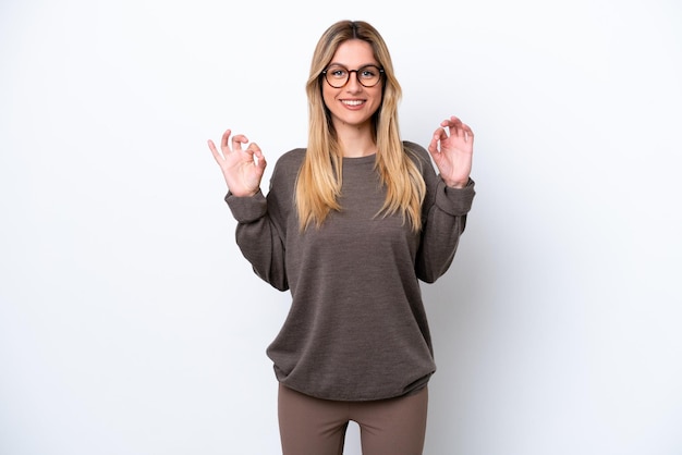 Young Uruguayan woman isolated on white background showing ok sign with two hands