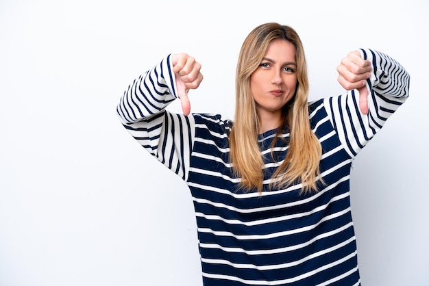 Young Uruguayan woman isolated on white background showing thumb down with two hands