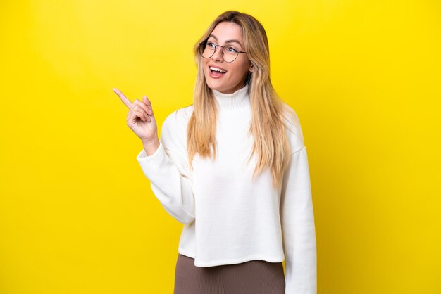 Young Uruguayan woman isolated on yellow background intending to realizes the solution while lifting a finger up