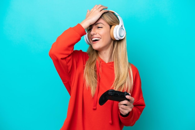 Young Uruguayan woman playing with a video game controller isolated on blue has realized something and intending the solution