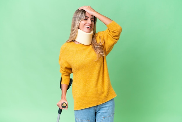 Young Uruguayan woman wearing neck brace and crutches over isolated background has realized something and intending the solution