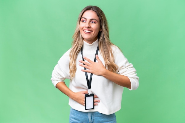 Young Uruguayan woman with ID card over isolated background smiling a lot