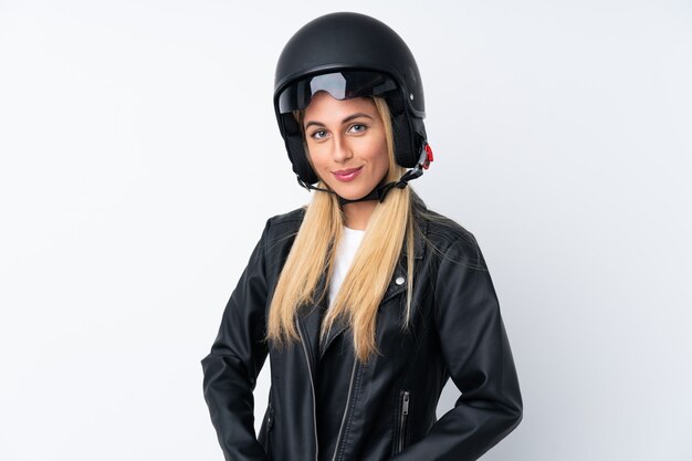 Young Uruguayan woman with a motorcycle helmet over isolated wall white wall