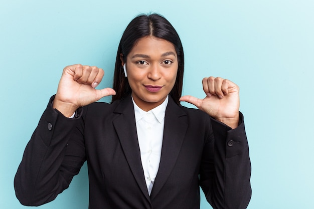 Young Venezuelan business woman isolated on blue background feels proud and self confident, example to follow.