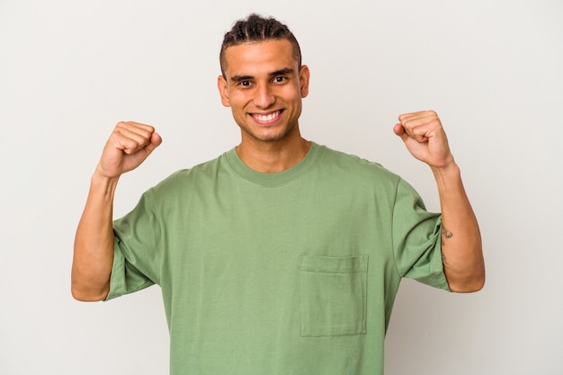 Young venezuelan man isolated on white background cheering carefree and excited. Victory concept.