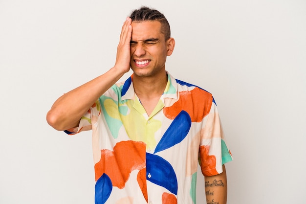 Young venezuelan man isolated on white background forgetting something, slapping forehead with palm and closing eyes.