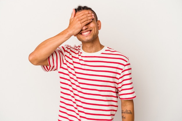 Young venezuelan man isolated on white background laughs joyfully keeping hands on head. Happiness concept.