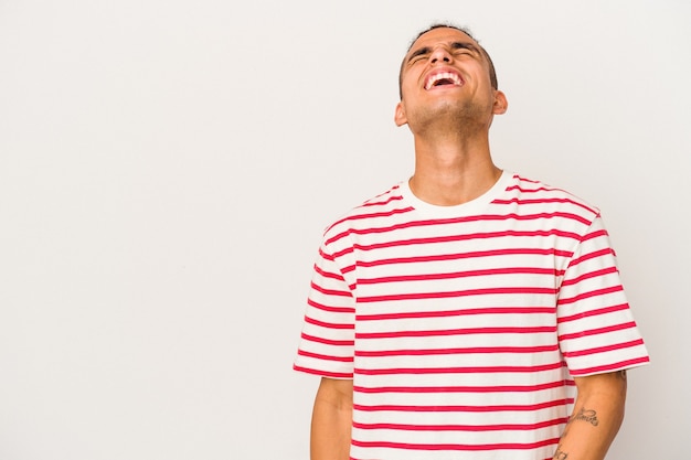 Young venezuelan man isolated on white background shouting very angry, rage concept, frustrated.