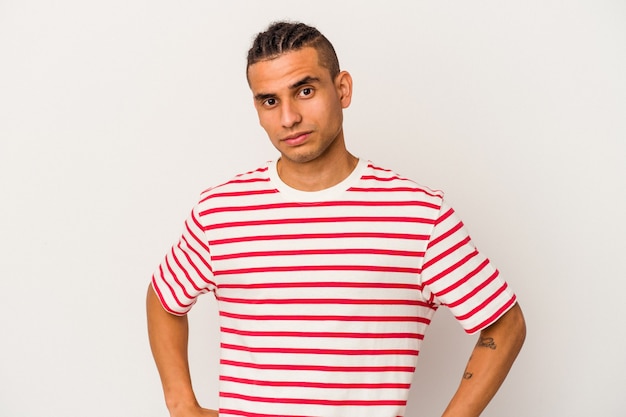 Young venezuelan man isolated on white wall sad, serious face, feeling miserable and displeased.