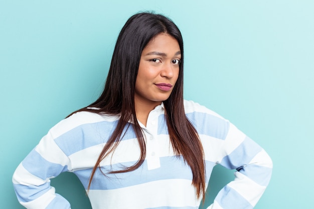 Young Venezuelan woman isolated on blue background confused, feels doubtful and unsure.