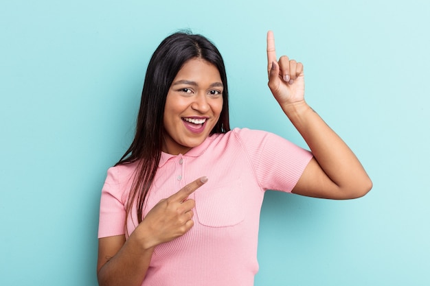 Young Venezuelan woman isolated on blue background dancing and having fun.