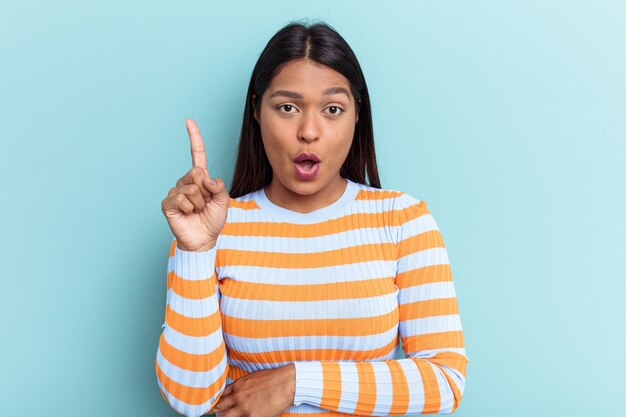 Young Venezuelan woman isolated on blue background having some great idea, concept of creativity.