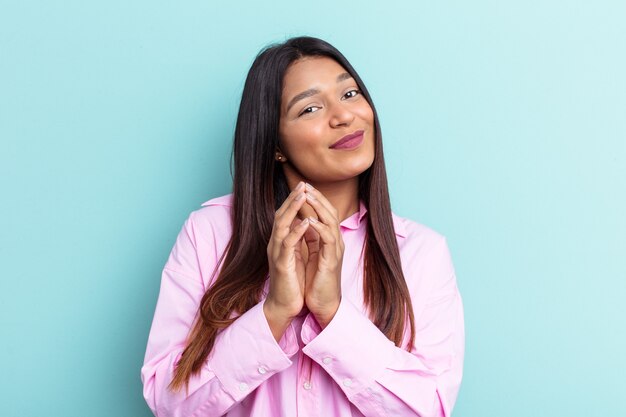 Young Venezuelan woman isolated on blue background making up plan in mind, setting up an idea.