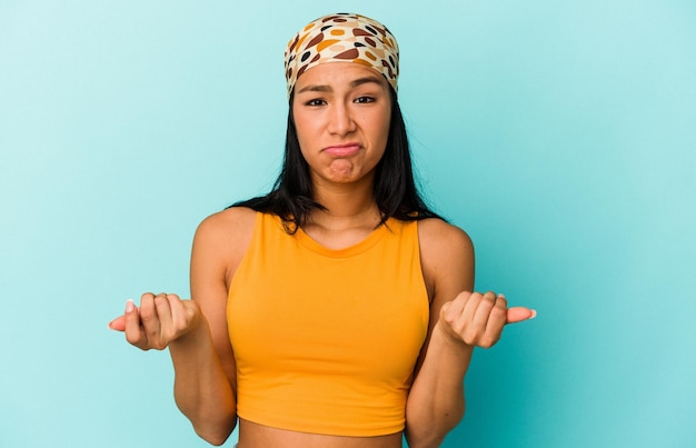 Young Venezuelan woman isolated on blue background showing that she has no money