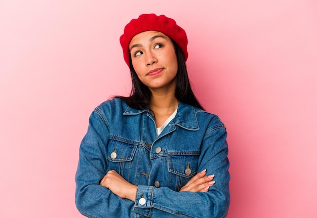 Young Venezuelan woman isolated on pink background dreaming of achieving goals and purposes