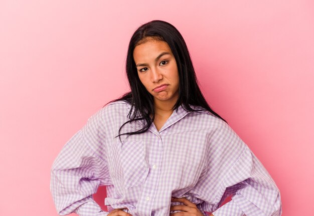 Photo young venezuelan woman isolated on pink background sad, serious face, feeling miserable and displeased.