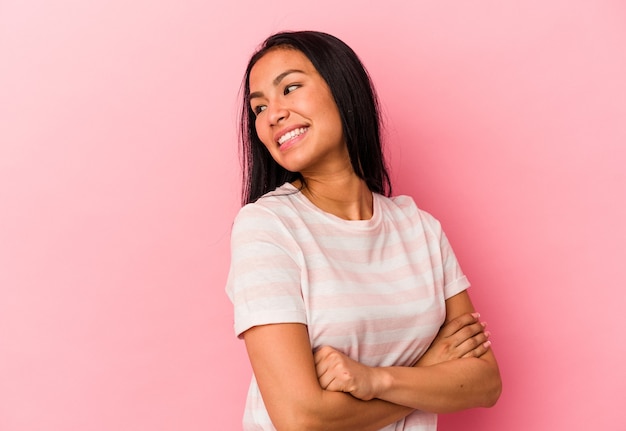 Young Venezuelan woman isolated on pink wall laughing and having fun.