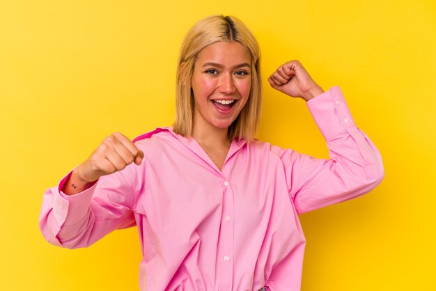 Young venezuelan woman isolated on yellow background dancing and having fun.
