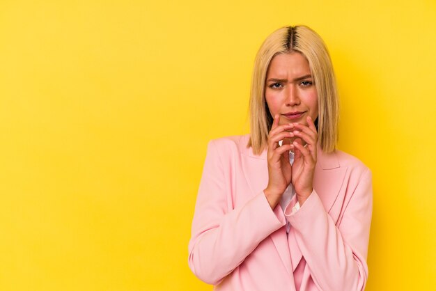 Young venezuelan woman isolated on yellow background making up plan in mind, setting up an idea.