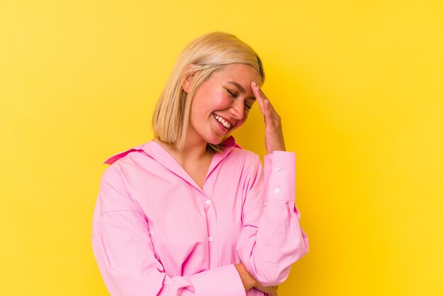 Young venezuelan woman isolated on yellow wall blink at the front through fingers, embarrassed covering face