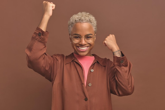 Young very happy african american woman waving hands\
celebrating victory