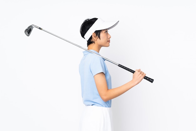 Young Vietnamese golfer woman over isolated white wall playing golf