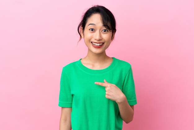 Young Vietnamese woman isolated on pink background with surprise facial expression