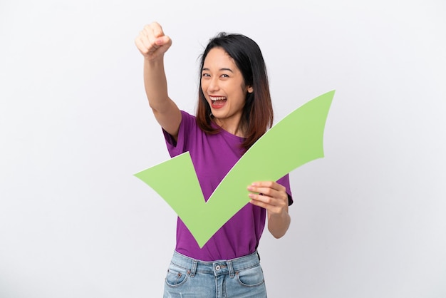 Young Vietnamese woman isolated on white background holding a check icon and celebrating a victory