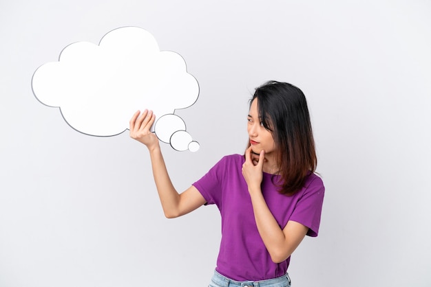 Young Vietnamese woman isolated on white background holding a thinking speech bubble