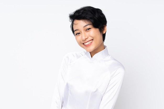 Young Vietnamese woman with short hair wearing a traditional dress over isolated white