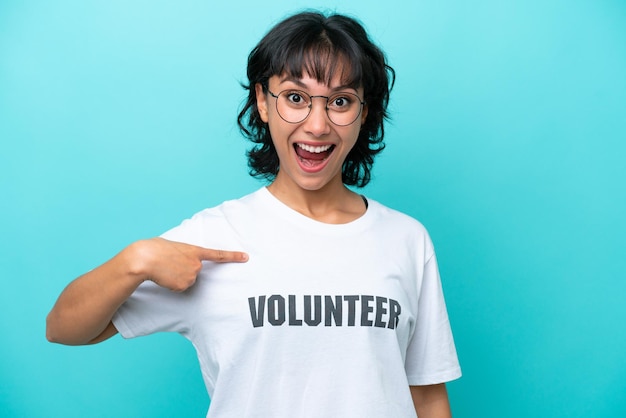 Young volunteer Argentinian woman isolated on blue background with surprise facial expression