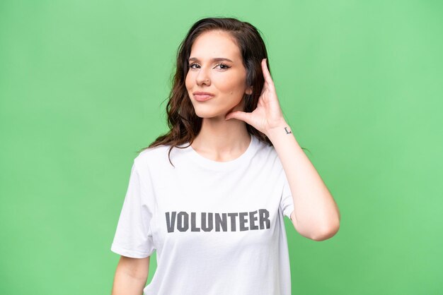 Photo young volunteer caucasian woman over isolated background having doubts