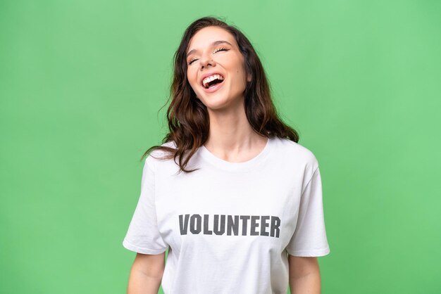 Young volunteer caucasian woman over isolated background laughing