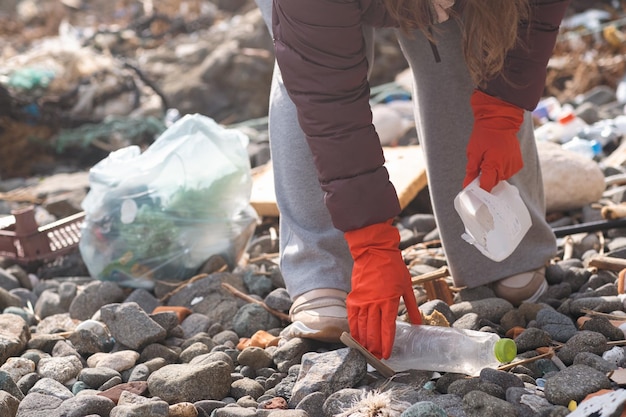 Young volunteer remove garbage plastic and paper waste bottles trash ecology pollution problem