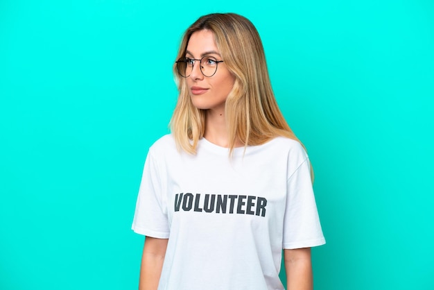 Young volunteer Uruguayan woman isolated on blue background looking to the side