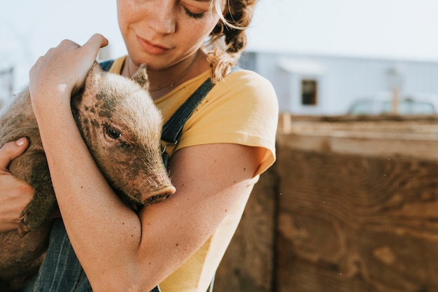 Young volunteer with a piglet, The Sanctuary at Soledad, Mojave