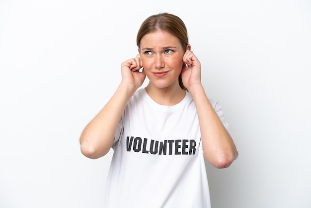 Young volunteer woman isolated on white background frustrated and covering ears