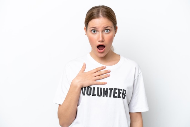 Young volunteer woman isolated on white background surprised and shocked while looking right