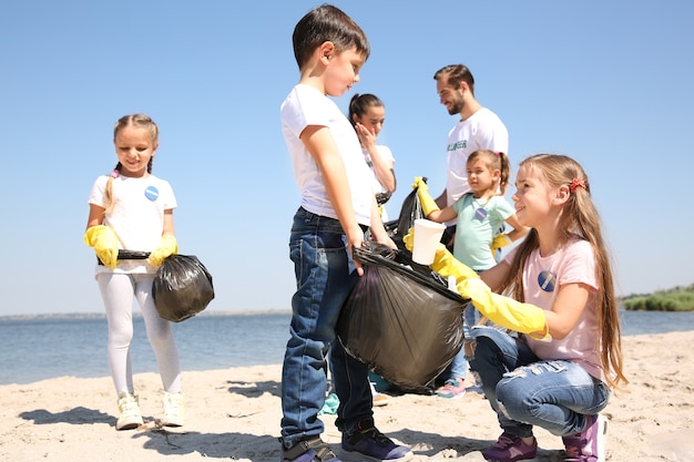 Фото Молодые волонтеры и дети собирают мусор на пляже