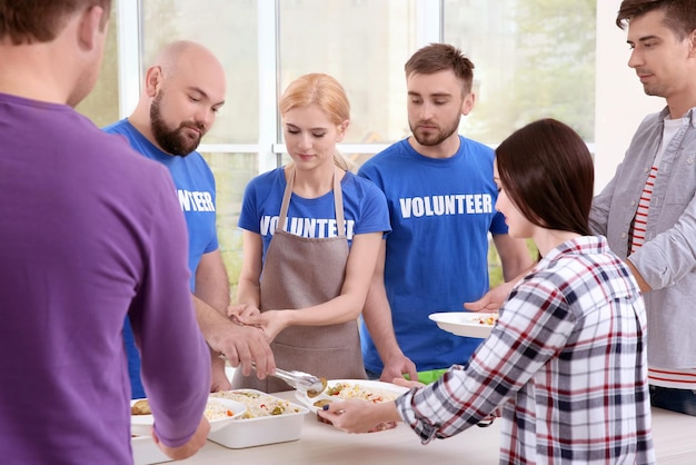 Young volunteers serving food to homeless people