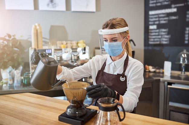 Giovane cameriere che mostra modi alternativi di preparare il caffè Foto Premium